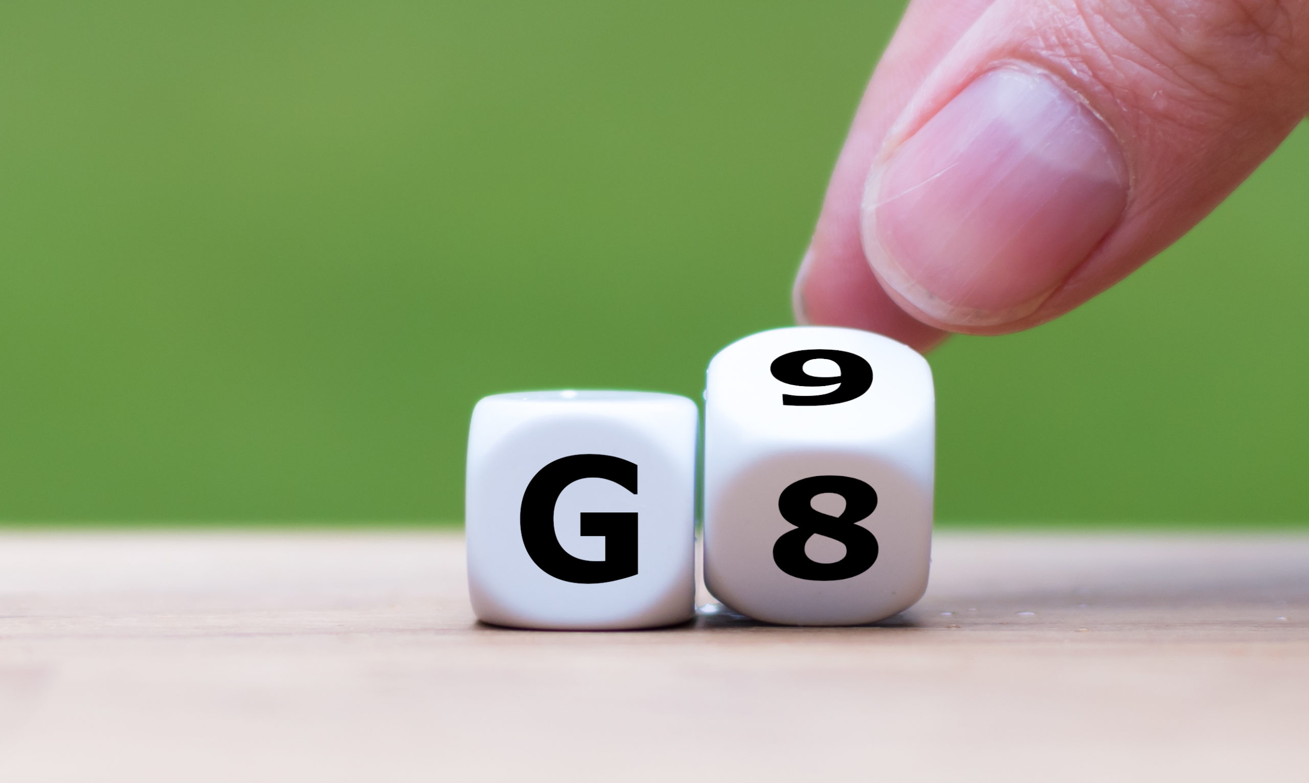Symbol for the duration of the secondary school in Germany. Hand turns a dice and changes the expression G8 (8 years) to G9 (9 years), or vice versa.